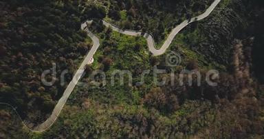 无人机飞过令人惊叹的山路<strong>蜿蜒</strong>。 宁静的森林树木和蛇形巷道的高空俯视图4K